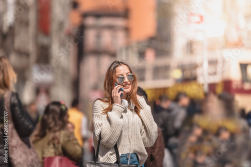 Beautiful woman uses smartphone while walking