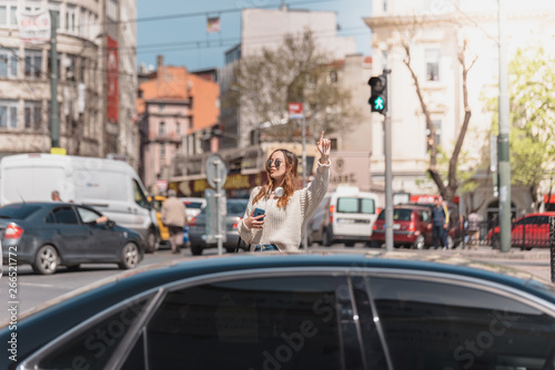 Beautiful woman looks for a taxi at street