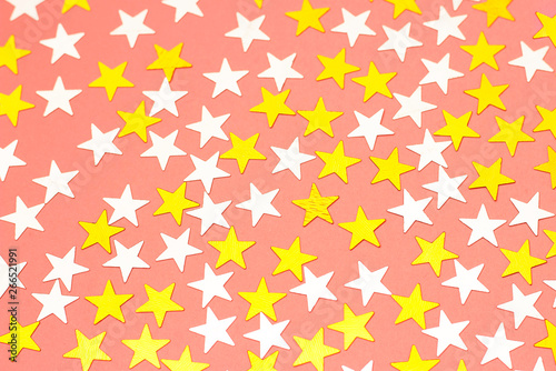 Golden stars of confetti on a white background, top view