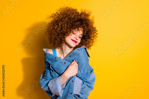 Close-up portrait of her she nice cute lovely charming attractive winsome sweet cheerful wavy-haired girl covering cosy jacket isolated over bright vivid shine yellow background