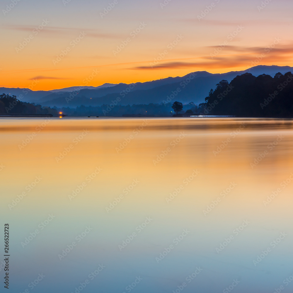 Red sunset under a calm river