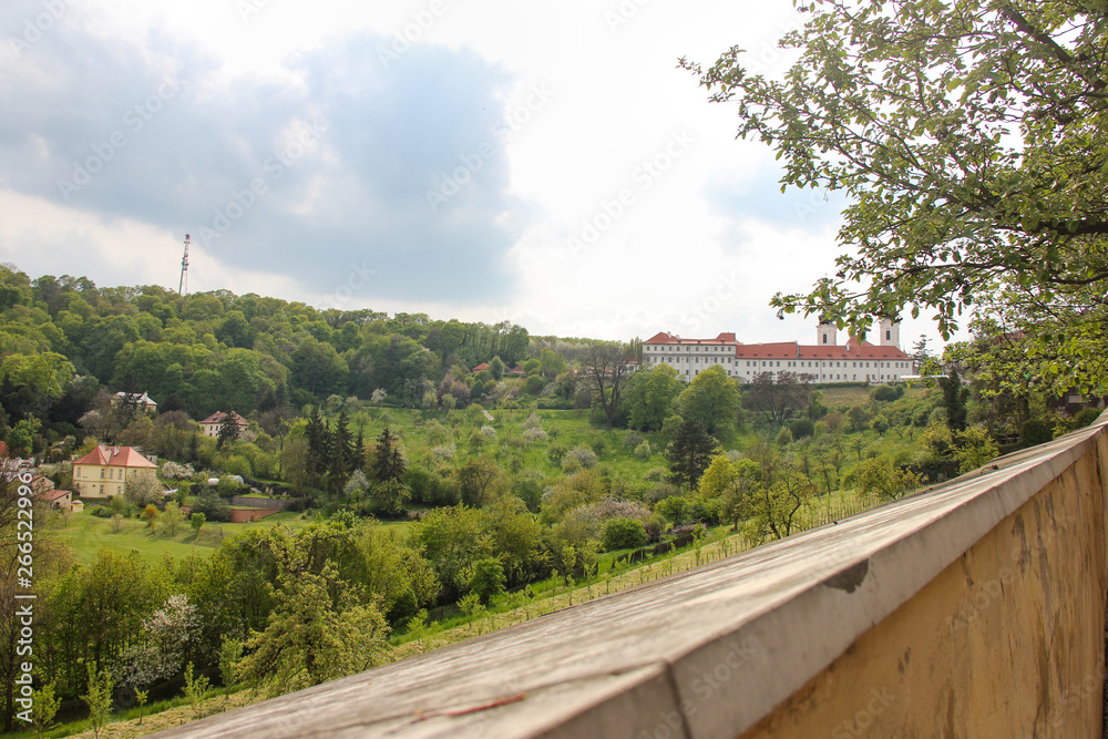 Panoramic view of Strahov Monastery through the wall fence in Hradcany, Prague, Czech Republic. Diagonal wall on foreground close up