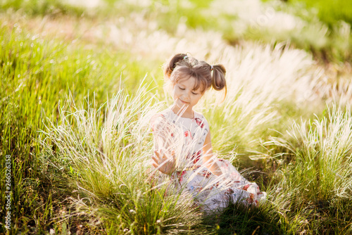 portrait of a little beautiful girl child on the background of a blooming park in spring, summer flower mood.