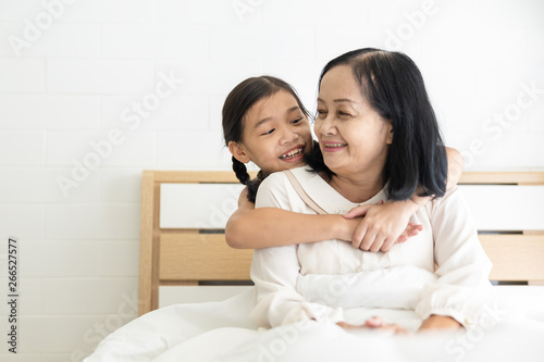grandmother and granddaughter talking happy family on the bedroom and white bed