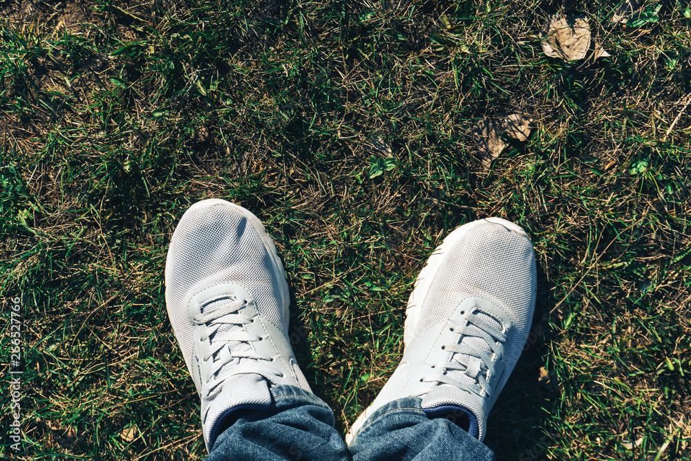 white sneakers on green grass top view