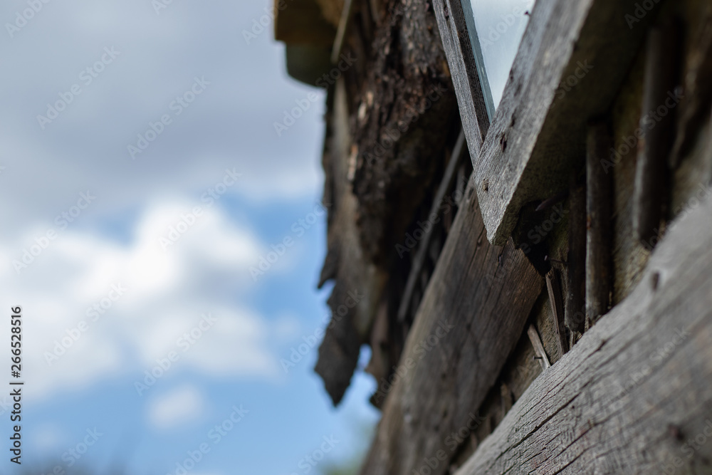 The window of a dilapidated barn at an angle on the background of a cloudy sky at noon in open space. Canon EOS 77D, f/3.5, ISO 100, 1/640. Noon. Marino. Michurinsk