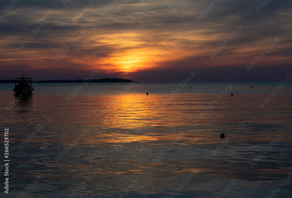 Sunset on the sea in Fazana,Croatia with ship silhouette