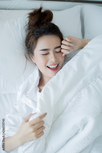 Beautiful young woman lying down in the bed and sleeping.