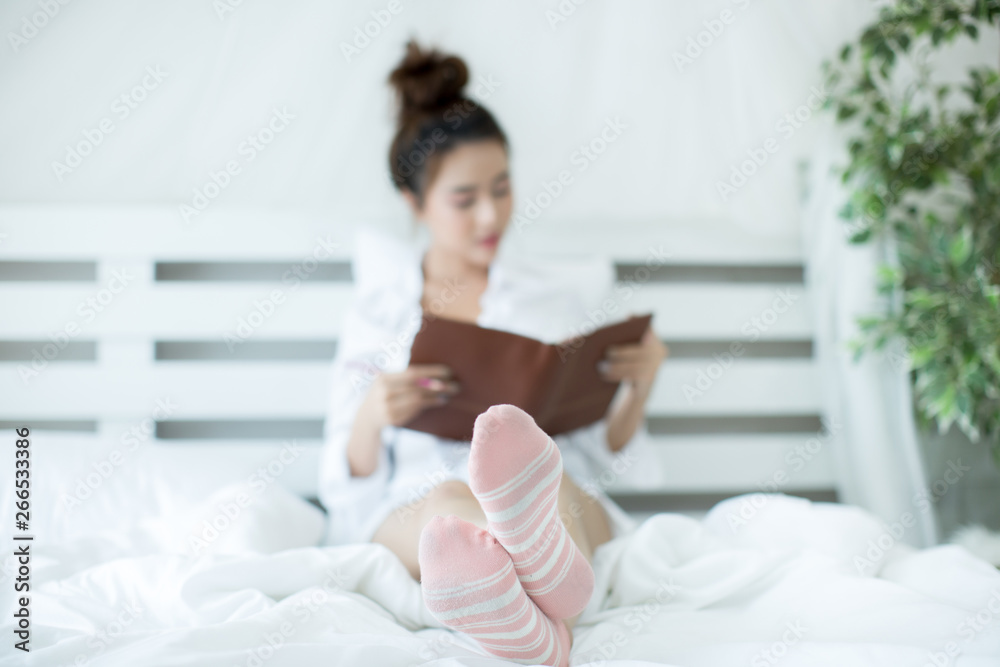 Lifestyle happy young Asian woman enjoying lying on the bed reading book at home. Lifestyle happy young Asian woman enjoying lying on the bed reading book at home.