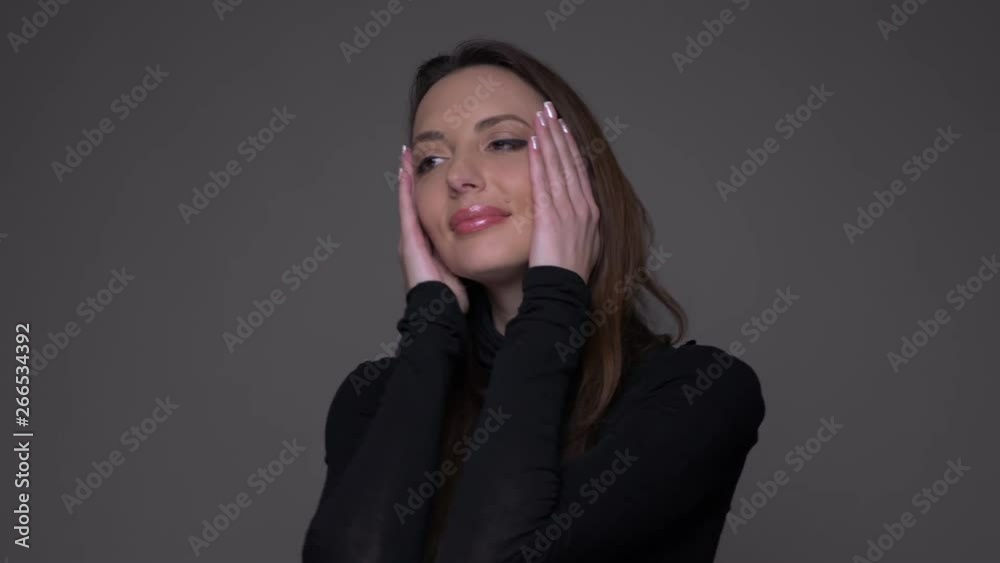 Closeup portrait of adult attractive caucasian female dancing with joy in front of the camera with background isolated on gray Closeup portrait of adult attractive caucasian female dancing with joy in front of the camera with background isolated on gray