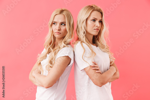 Mystery blonde twins wearing in t-shirts standing back to back
