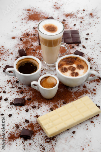 Different types of coffe ,espreso,long coffe ,latte,coffe with milk,on sweet background with coffe beans and chocolate.