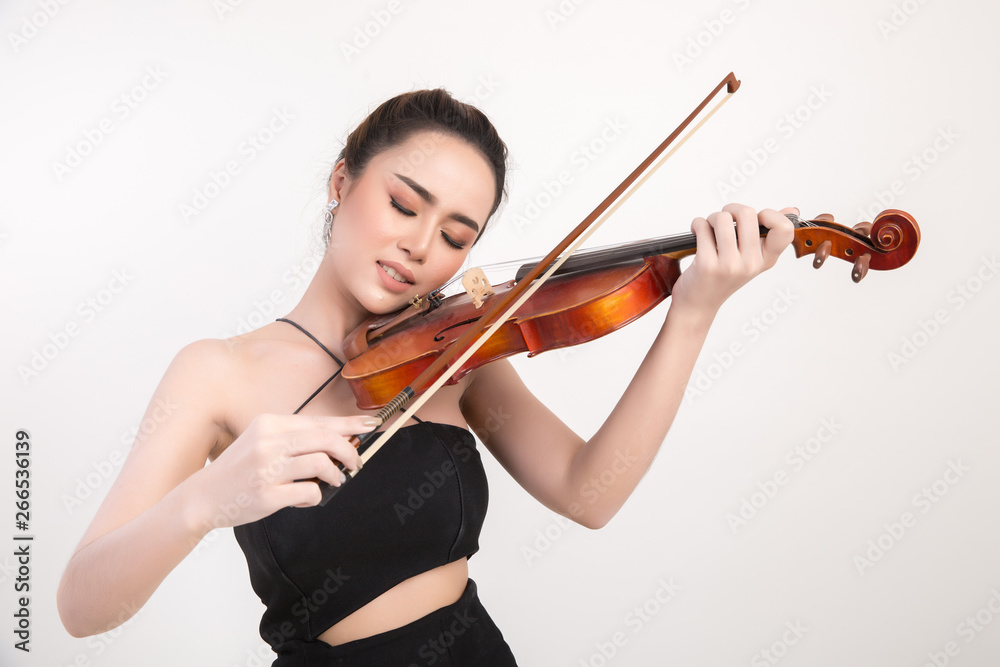 Beautiful young woman playing violin over white background Beautiful young woman playing violin over white background