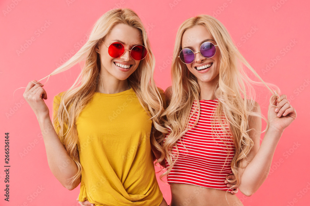 Playful blonde twins in sunglasses posing together Playful blonde twins in sunglasses posing together