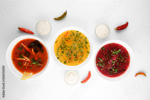 Set of soups from worldwide cuisines, healthy food,solyanka, russian borscht, chicken soup on silver background. Top view.