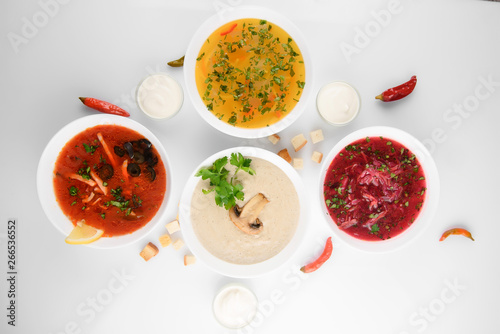 Set of soups from worldwide cuisines, healthy food. Cream soup with mushrooms,solyanka, russian borscht, chicken soup on silver background. Top view.