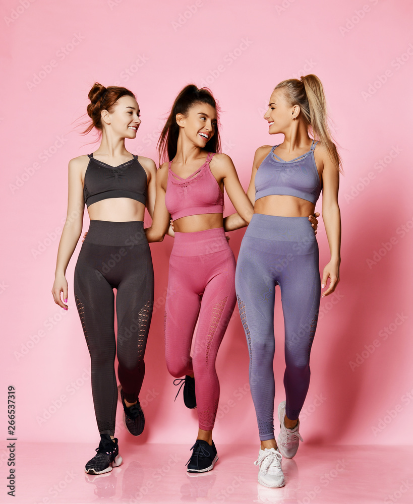 Group of three sport girls international friends in modern sports wear walk  together and enjoy chatting Stock Photo