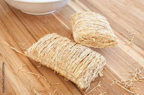 Shredded wheat biscuits on cutting board.