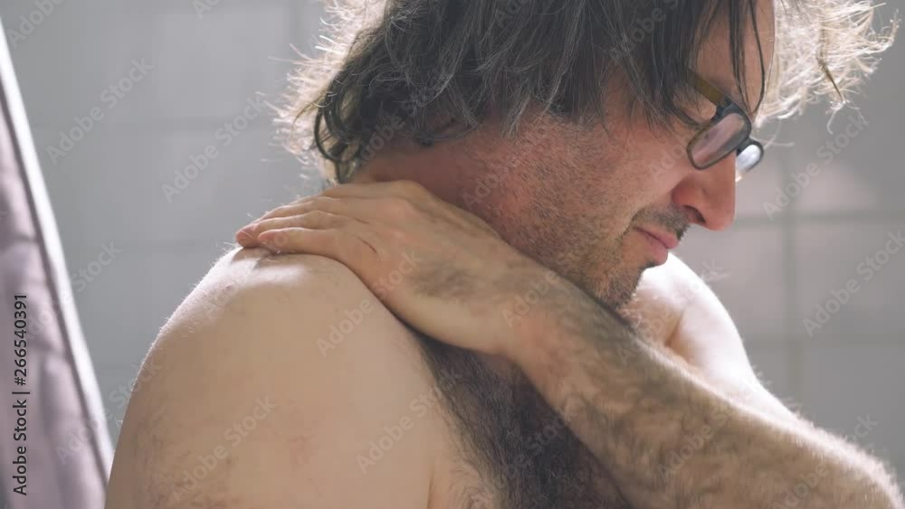 Man massaging his shoulder as he feels pain and discomfort.