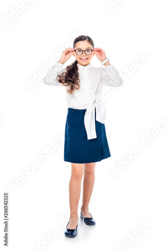 adorable schoolgirl in formal wear and glasses looking at camera and smiling Isolated On White
