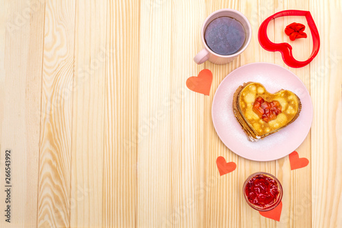 Fototapeta Naklejka Na Ścianę i Meble -  Heart shaped pancakes for romantic breakfast with strawberry jam and black tea. Shrovetide (carnival) concept. On wooden background, top view