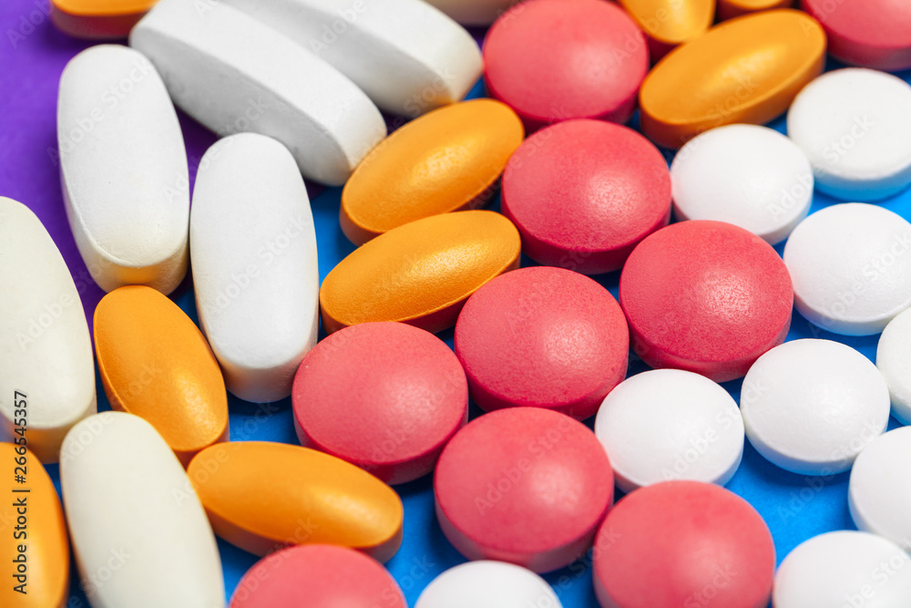 set of multi-colored tablets and capsules on a blue background set of multi-colored tablets and capsules on a blue background