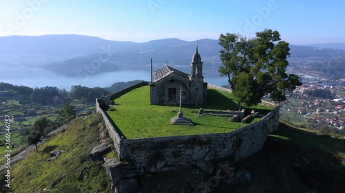 Aerial orbital of old hilltop Peneda chapel and Redondela town, Spain photo