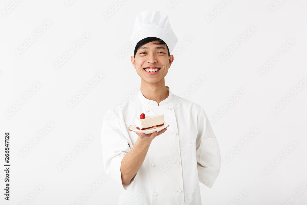 Image of joyful chinese chief man in white cook uniform smiling at camera while holding platter with tasty cheesecake Image of joyful chinese chief man in white cook uniform smiling at camera while holding platter with tasty cheesecake