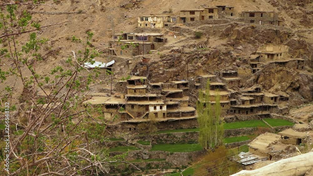Wide high-angle still shot view of Hundarman ghost town capturing its stacked old building ruins, and lower restored terraces, Kargil. Wide high-angle still shot view of Hundarman ghost town capturing its stacked old building ruins, and lower restored terraces, Kargil.