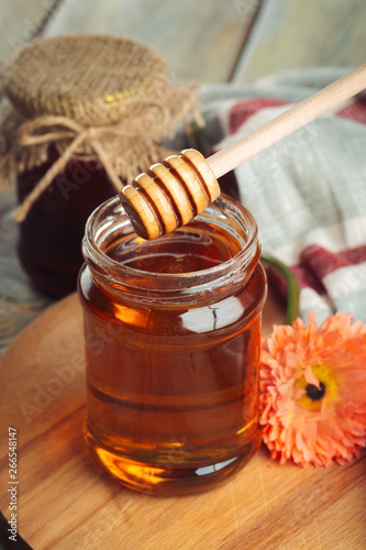 Honey background. Sweet honey in glass jar on wooden background.