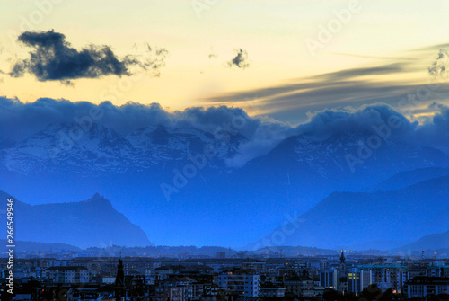 View of Turin (Torino) Italy at sunset looking toward Susa Valley with the backdrop of the Italian Alps and the Sacra di San Michele Church silhouetted