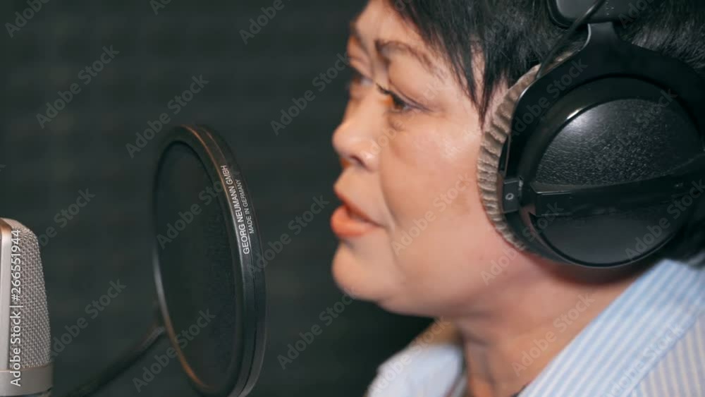 Singing woman in a recording studio. Adult woman recording a song in a recording studio. Singing woman in a recording studio. Adult woman recording a song in a recording studio.