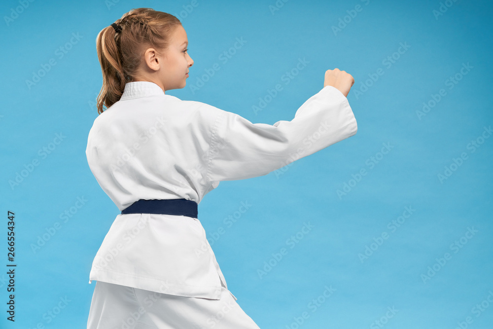 View from back of girl doing karate on isolated background View from back of girl doing karate on isolated background