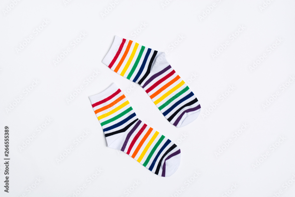 Pair of white socks with colorful striped pattern on white background. Copy space