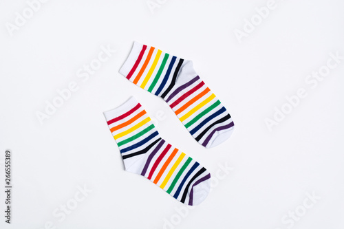 Pair of white socks with colorful striped pattern on white background. Copy space