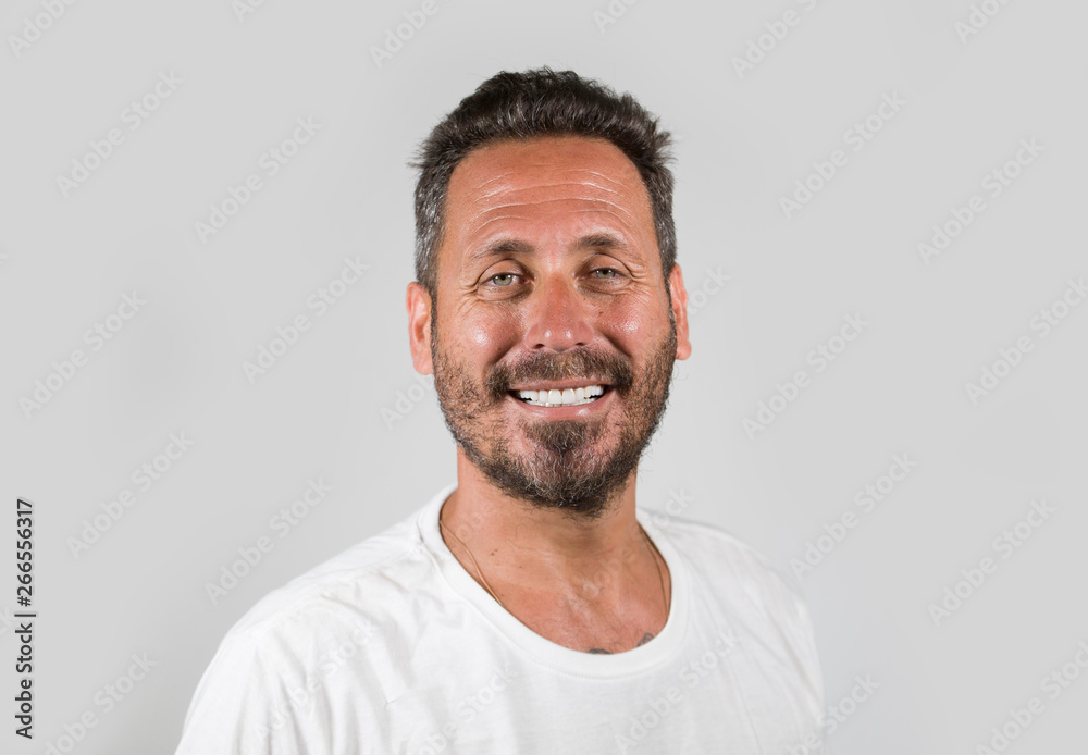 portrait of young happy and attractive man with blue eyes and beard looking cool smiling happy and confident wearing white t-shirt isolated on studio background portrait of young happy and attractive man with blue eyes and beard looking cool smiling happy and confident wearing white t-shirt isolated on studio background