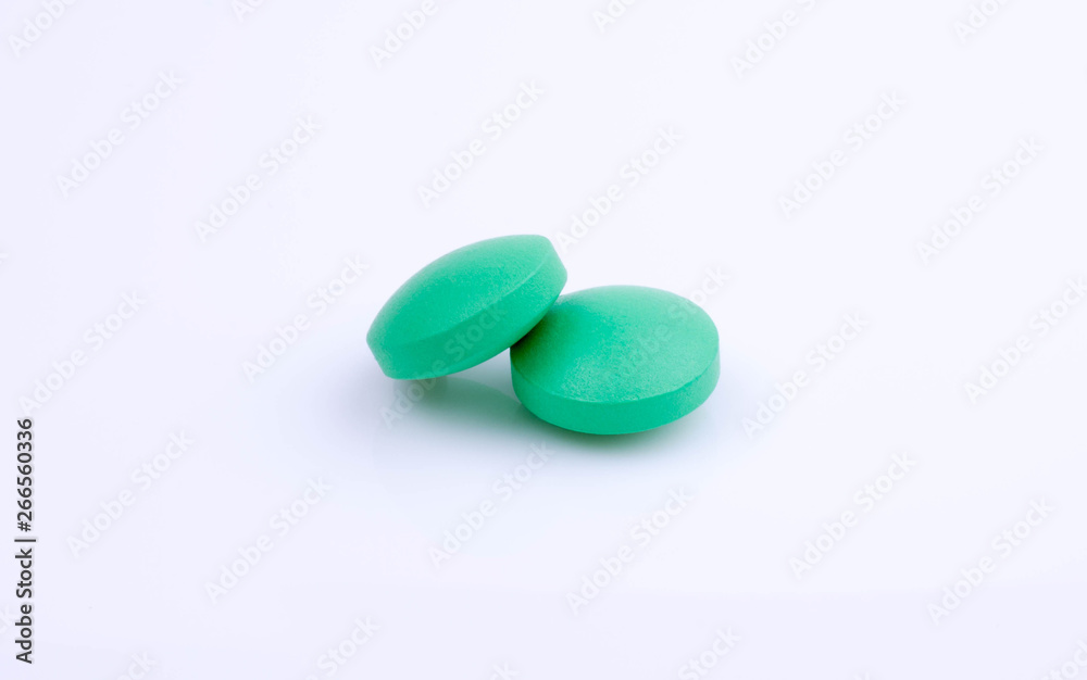 Obraz premium two green pills on white background