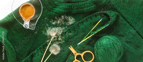 banner of knitting a sweater with knitting needles and a cup of coffee. background for yarn and knitting