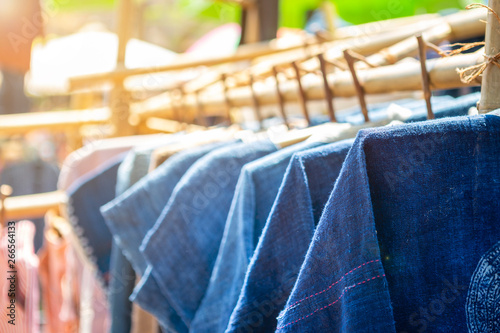 Blue cotton shirt haning on the bamboo rail, outday day light, shopping and fashion concept, Thai style blue cotton shirt