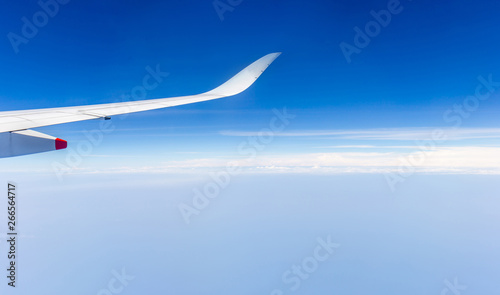 Airplane wing view out of the window the cloudy sky background, Travel and Holiday vacation concept