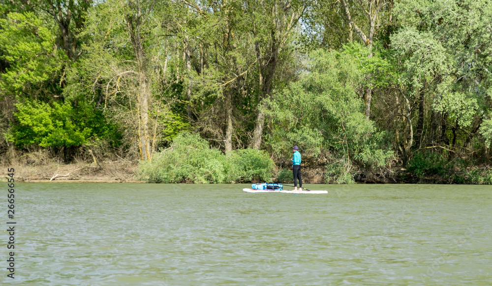 female kayaking on the sup board on green river