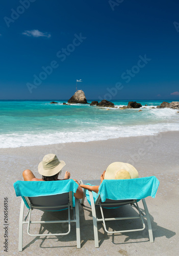 Couple on sunbeds relaxing at the beach in Lefkada © Netfalls