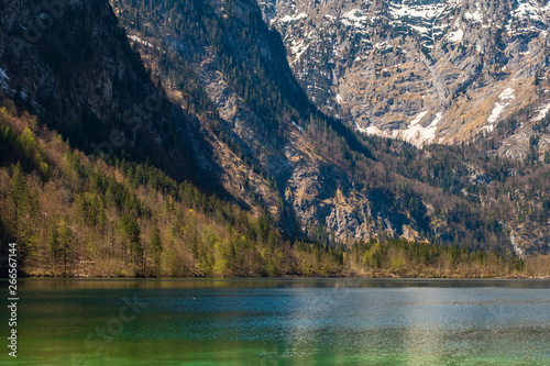 The snowy mountain peaks, trees, houses and lakes at Konigssee, Germany