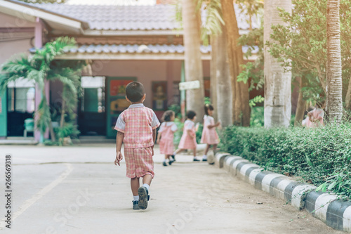 Back view of Boy followed girl friends on street to go to the classroom in school. © JinnaritT