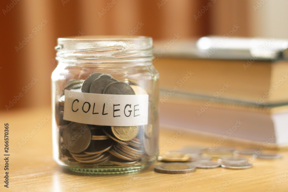 Coins in glass with books on the table.saving for education concept. Coins in glass with books on the table.saving for education concept.