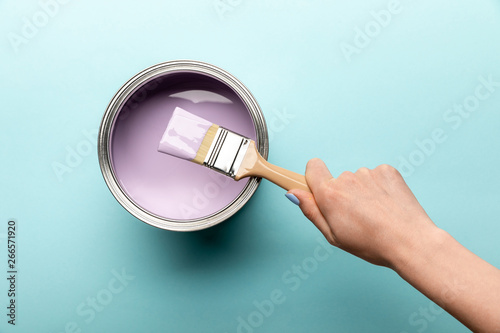 Fototapeta Naklejka Na Ścianę i Meble -  partial view of woman with brush and tin of purple paint on purple surface