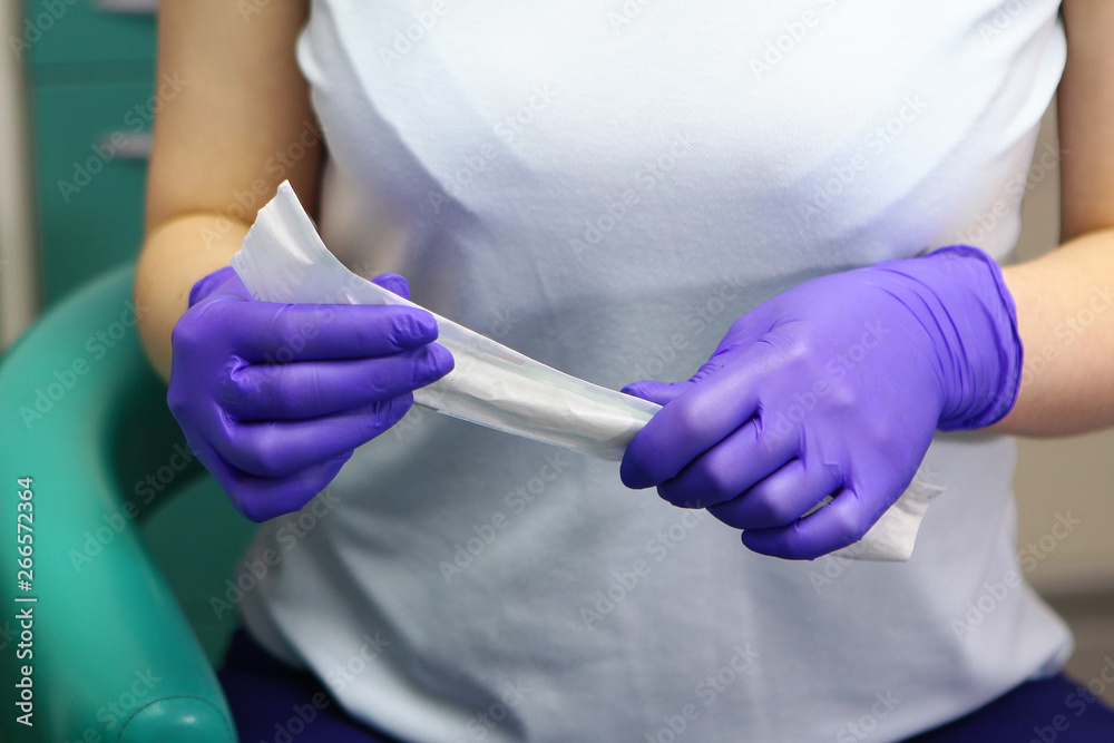 Macro photo of doctor's hands in gloves, which reveals a sterile mirror for dental work. The concept of beauty and health. Macro photo of doctor's hands in gloves, which reveals a sterile mirror for dental work. The concept of beauty and health.