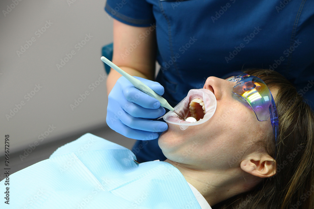 A dentist and assistant do a routine examination of the patient's mouth. The concept of health and beauty. A dentist and assistant do a routine examination of the patient's mouth. The concept of health and beauty.