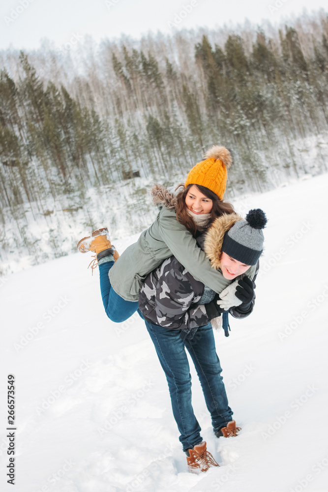 The happy couple in love at the forest nature park in cold season. Travel adventure love story