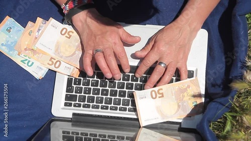 hands counting banknotes on a laptop3 photo